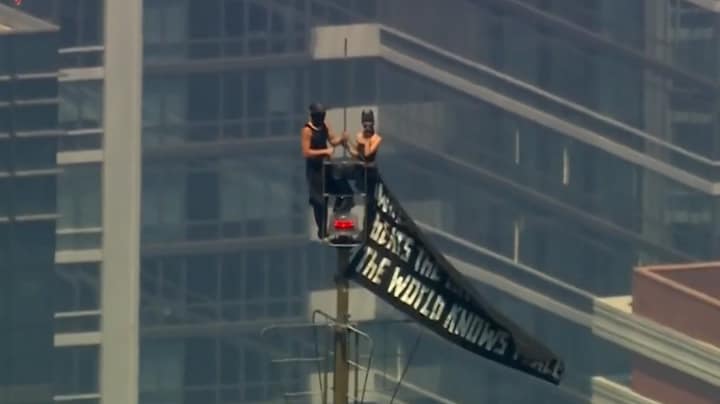 Mensen klimmen op antenne Empire State Building met spandoek