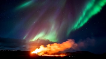 Kleurenspektakel in IJsland: noorderlicht boven spuwende vulkaan