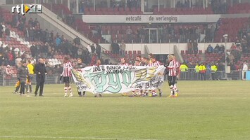 Voetbalfans PSV-spelers met spandoek voor overleden fan