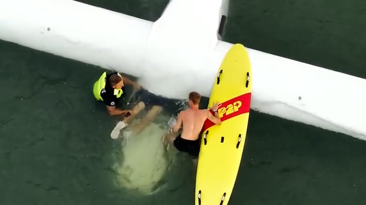 Dronebeelden: piloot VS maakt noodlanding op water, wordt bevrijd uit toestel