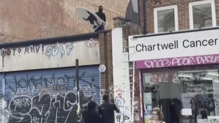 Mannen met bivakmutsen en ladder halen nieuw kunstwerk Banksy weg