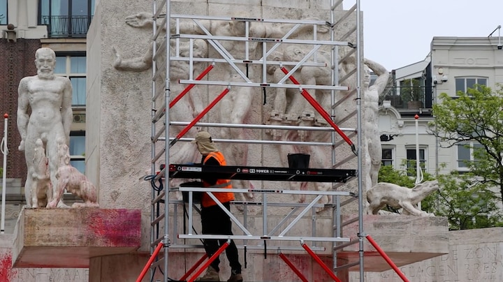 Schoonmakers verwijderen rode verf van Monument op de Dam