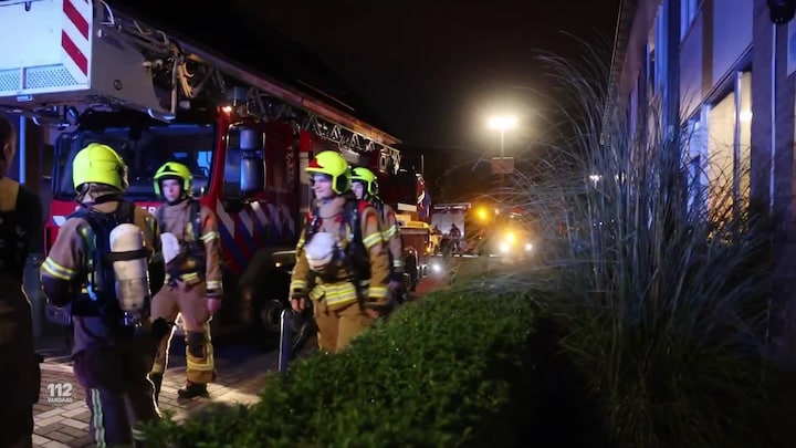 Vlammen bij de voordeur van een Rotterdamse woning na een enormer explosie